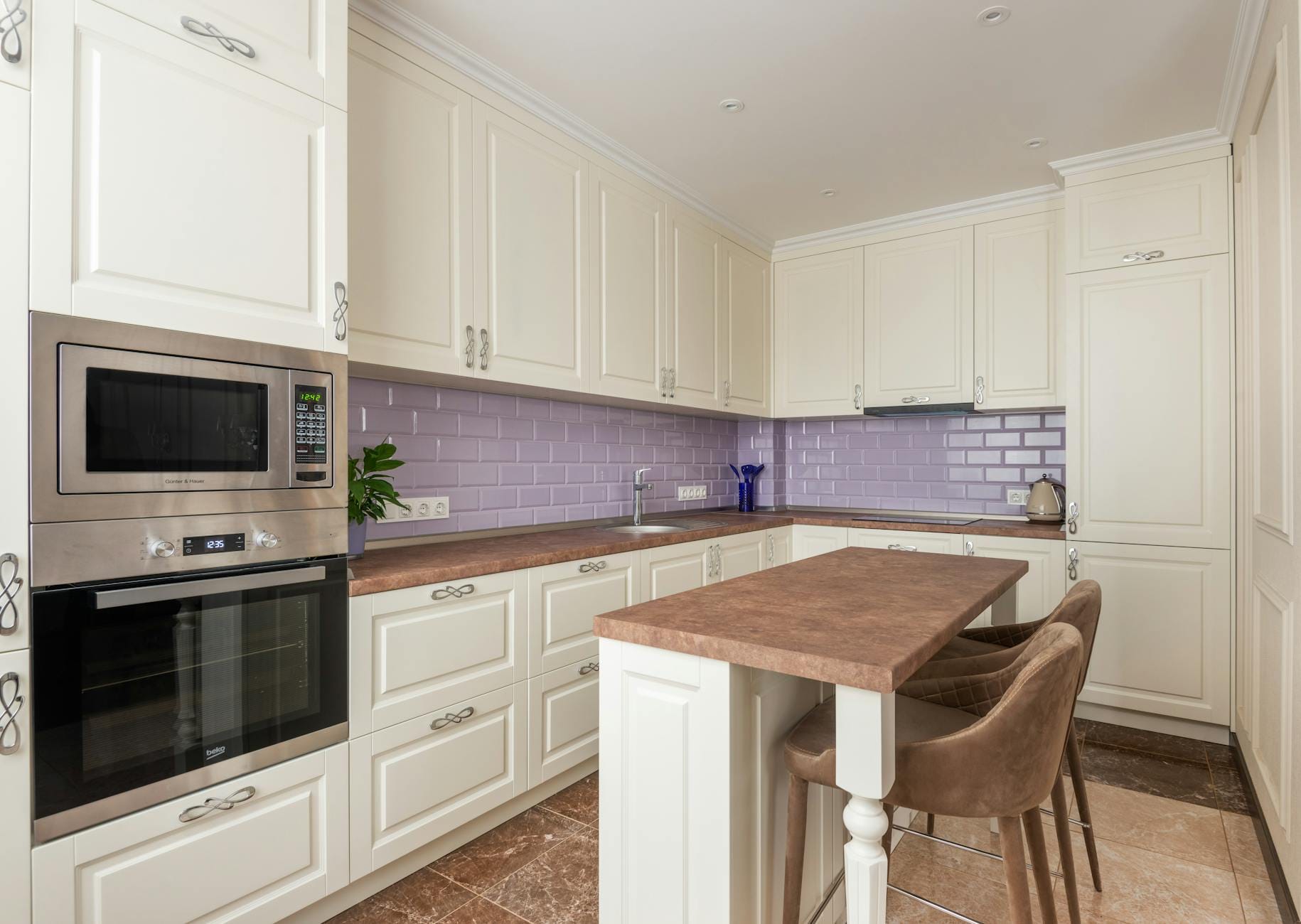 Biała nowoczesna kuchnia z marmurowym blatem i zabudowanym mikrofalownikiem