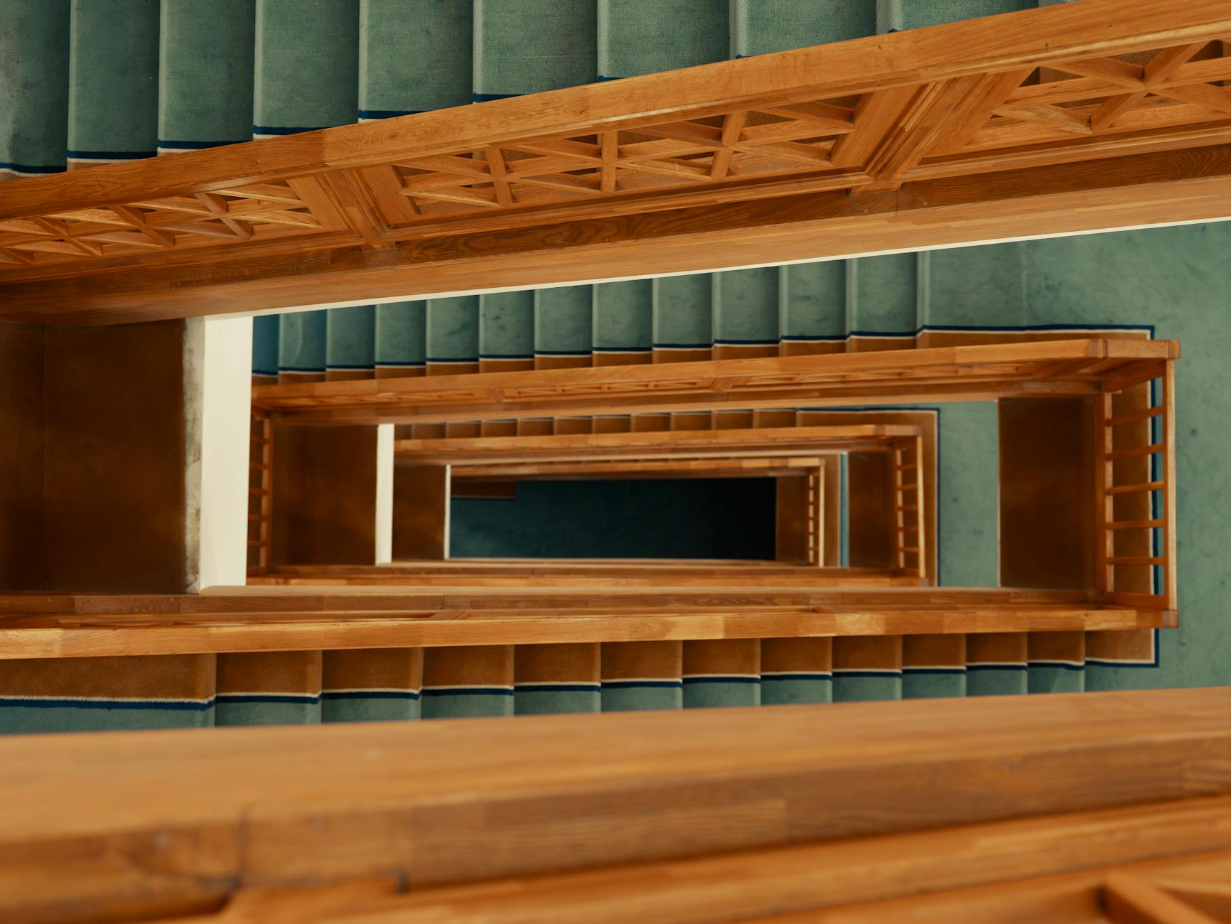 Drewniane schody z turkusową wykładziną widziane z góry