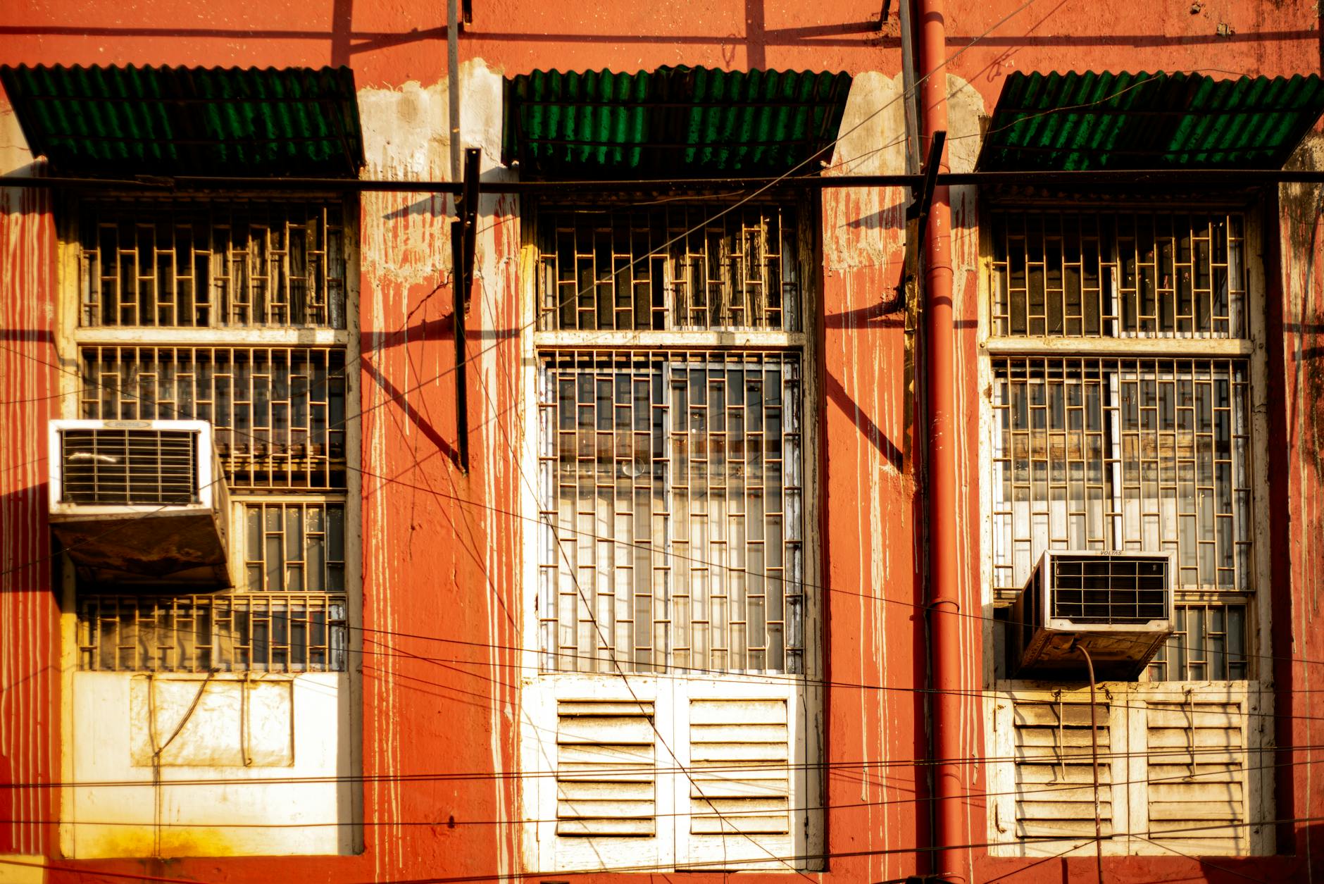 Elewacja starego budynku z kratami w oknach i klimatyzatorami