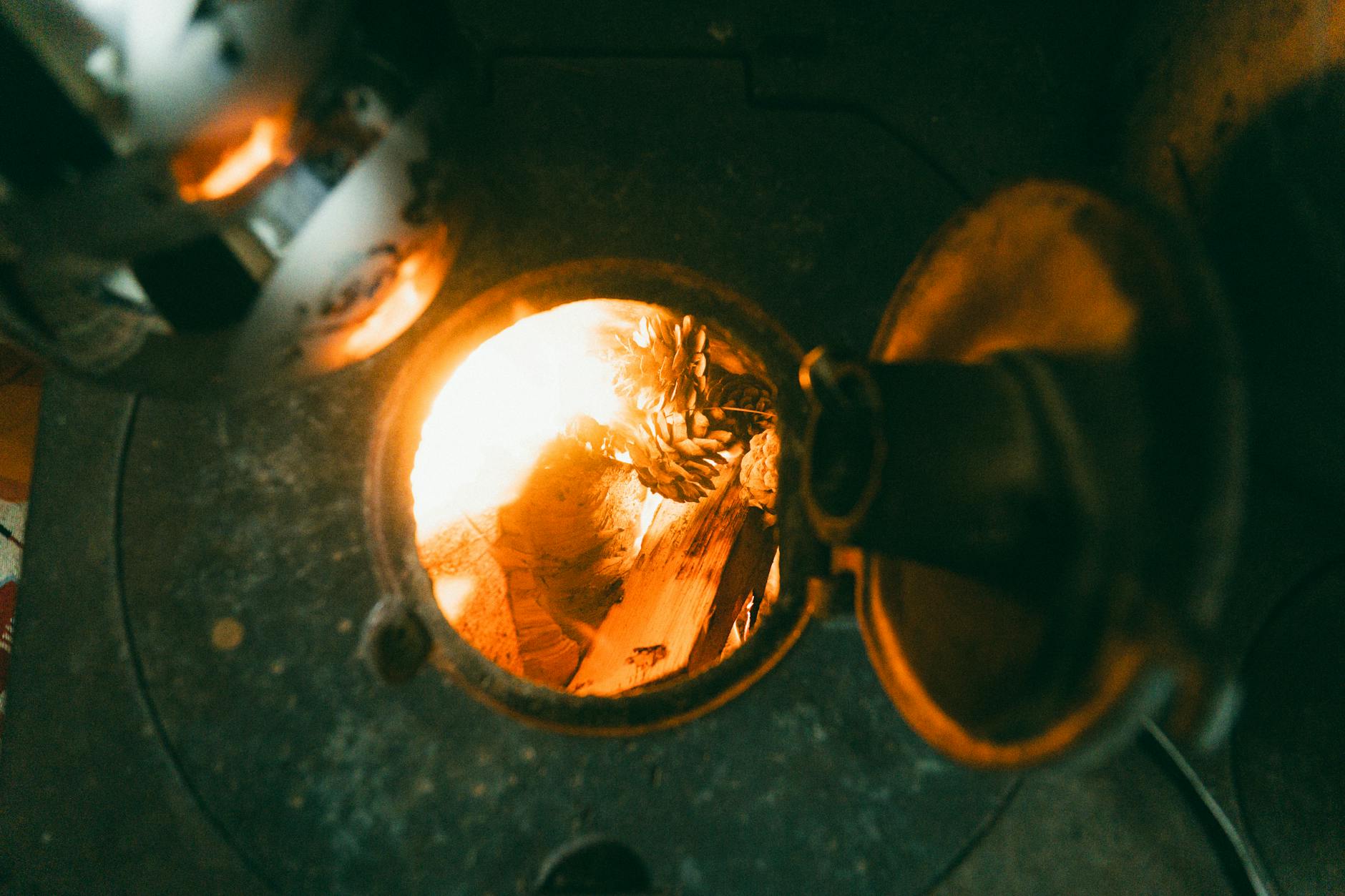 Płonące polana w żeliwnym piecu dodające ciepła starej kamienicy