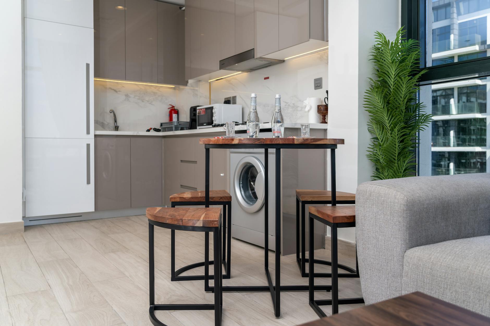 Wąska nowoczesna kuchnia w mieszkaniu z jasnymi szafkami i AGD