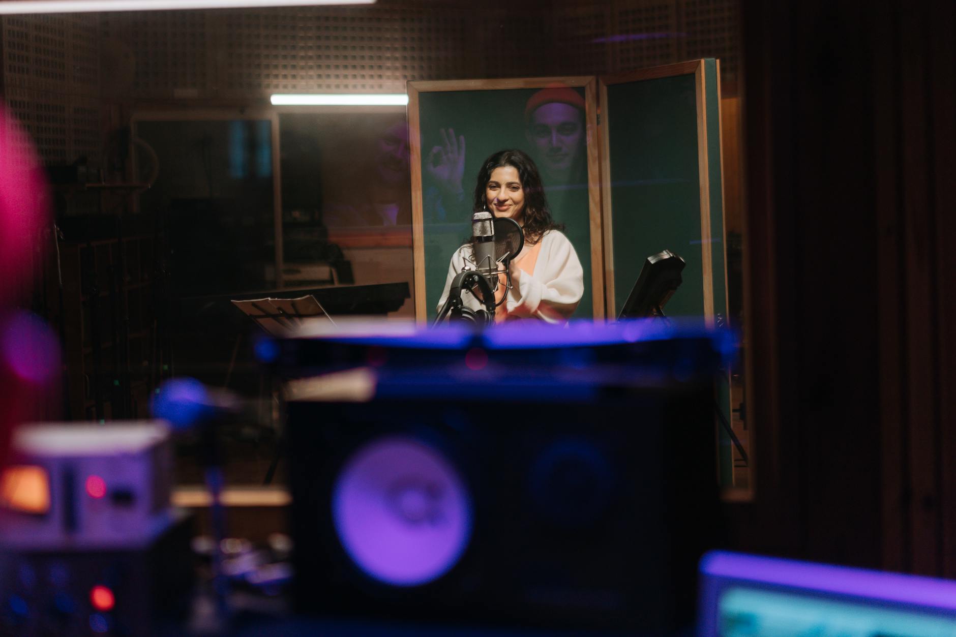 Wokalistka w studiu nagrań z wygłuszonymi ścianami i sprzętem audio
