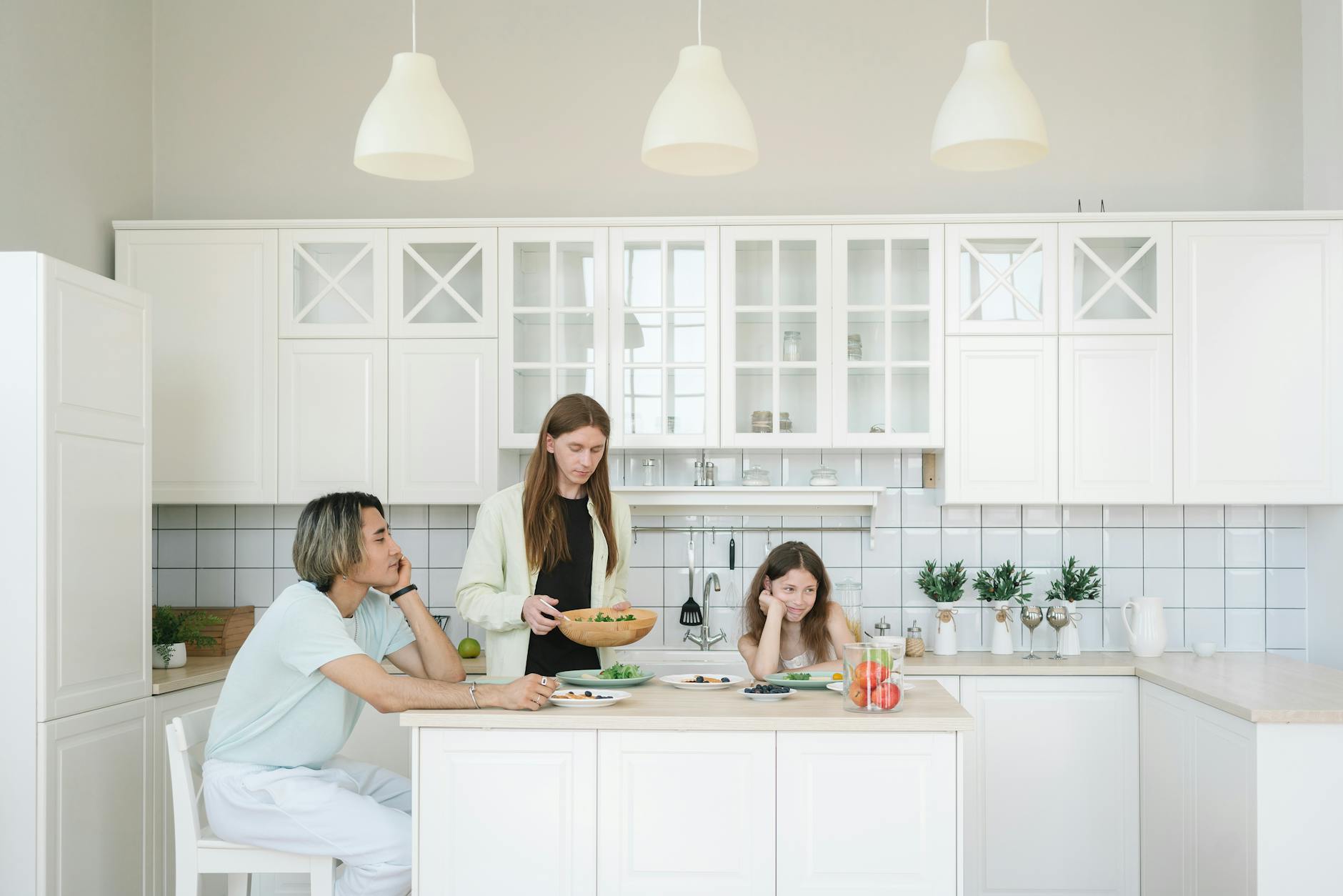 Rodzina jedząca śniadanie w jasnej, nowoczesnej kuchni