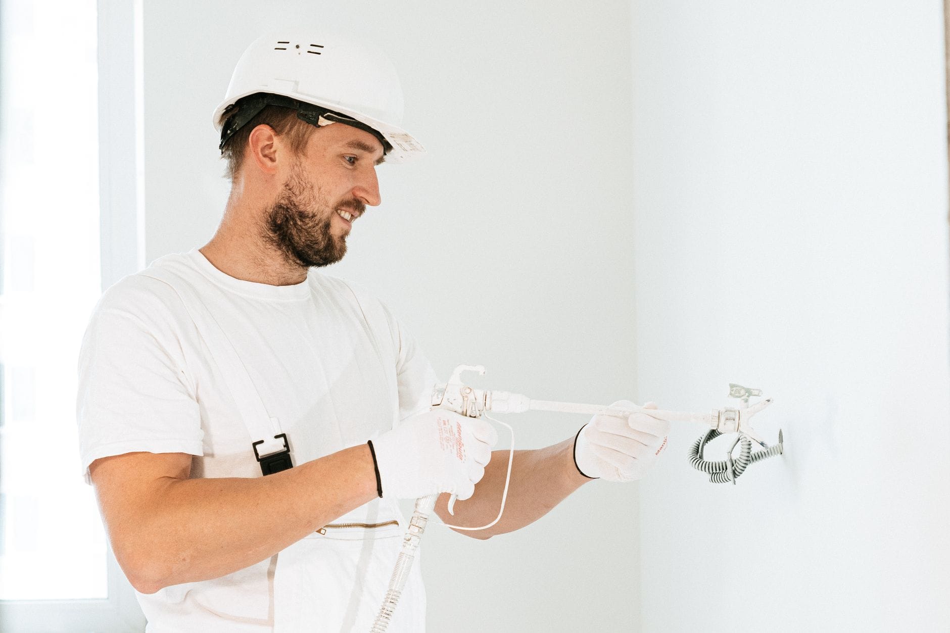 Elektryk w kasku montuje instalację elektryczną w nowym budynku